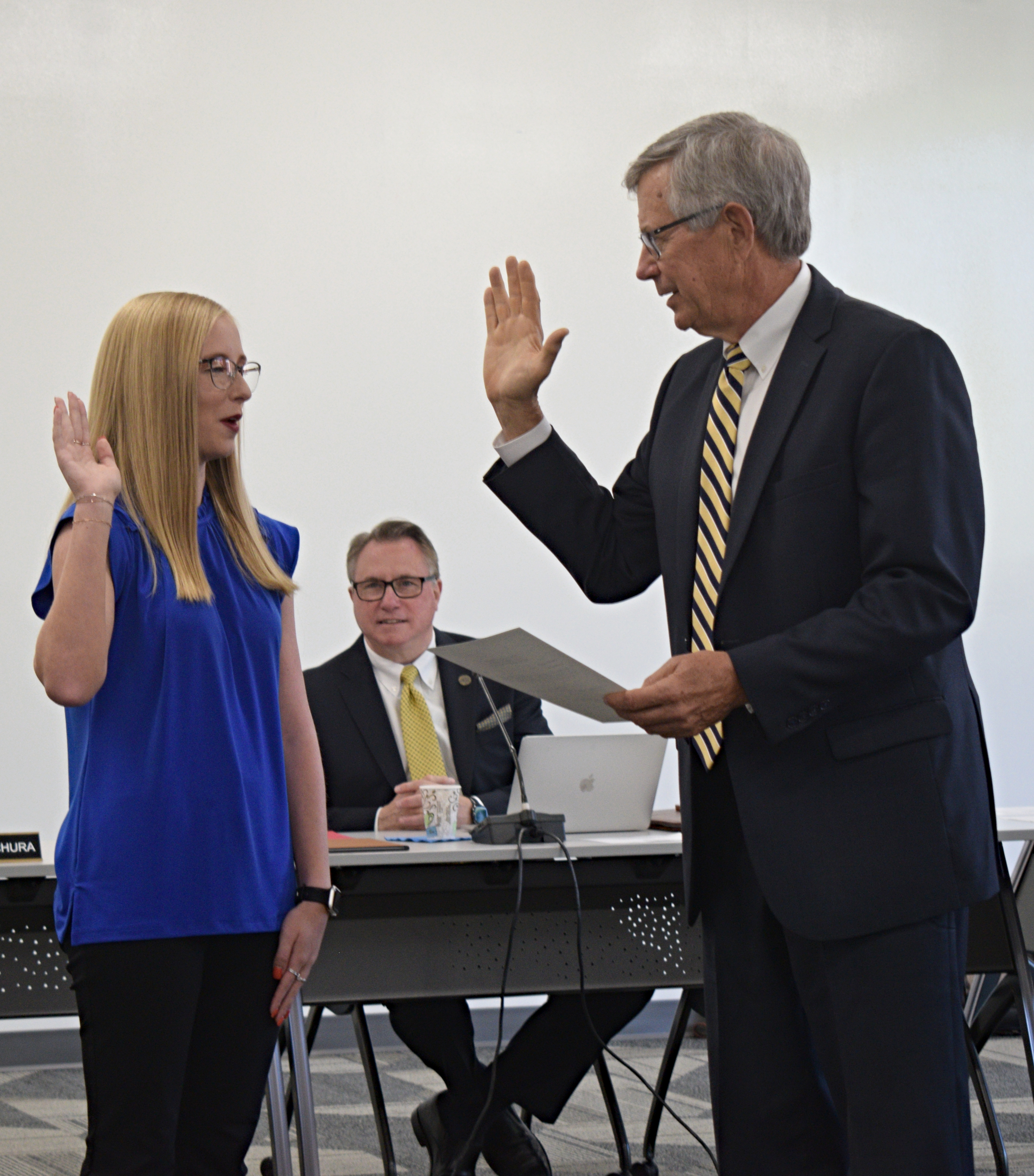 Student Trustee Gayle Baugh holds her hand up as she is being sworn in by the University attorney Brent Stuckey.
